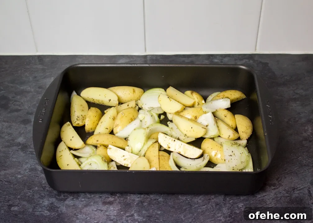 Crispy Oven-Baked Fish and Chips with Lemon Herb Tartar 3 Chopped potato, onion and seasoning in a roasting dish
