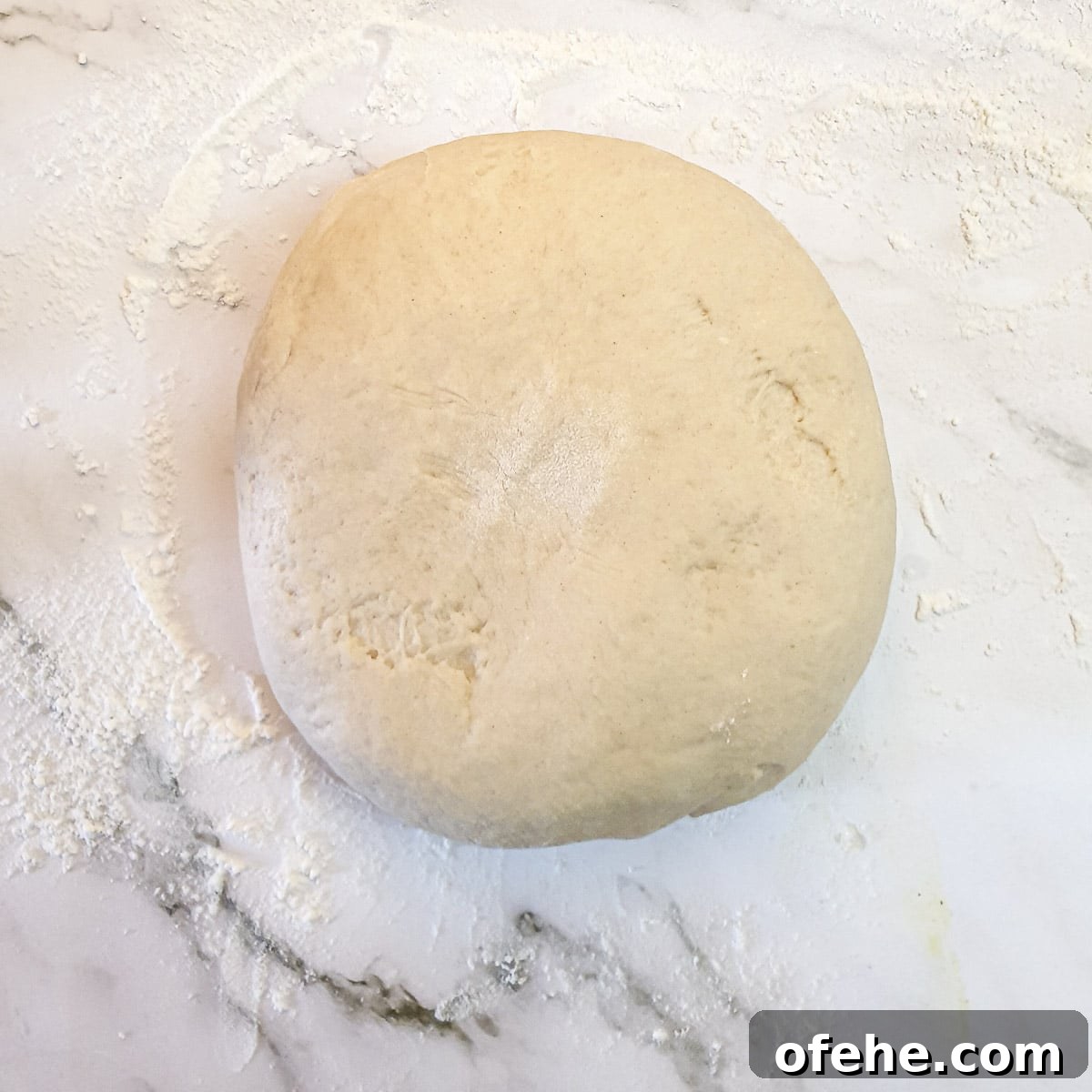 Homemade Chelsea Buns: Soft Cinnamon-Spiced Sticky Buns 11 A ball of dough on a floured surface.