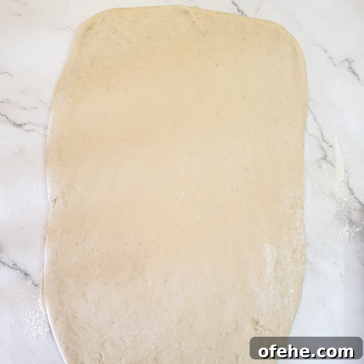 Homemade Chelsea Buns: Soft Cinnamon-Spiced Sticky Buns 12 Chelsea bun dough rolled into a rectangle.