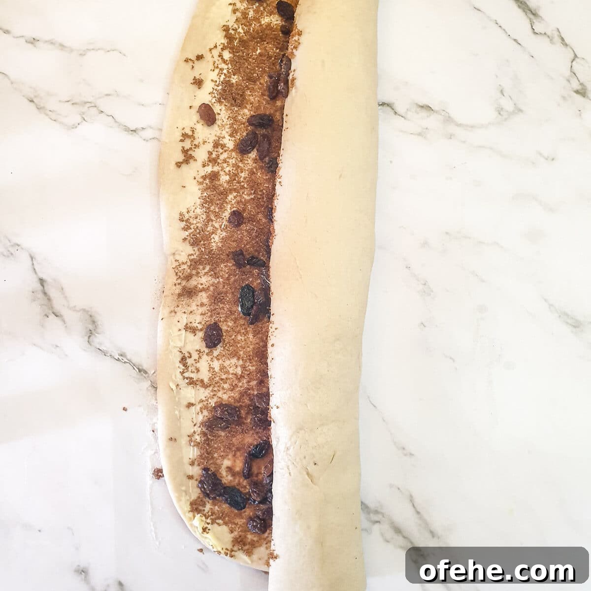 Homemade Chelsea Buns: Soft Cinnamon-Spiced Sticky Buns 14 The chelsea bun dough being rolled into a cylindrical shape.