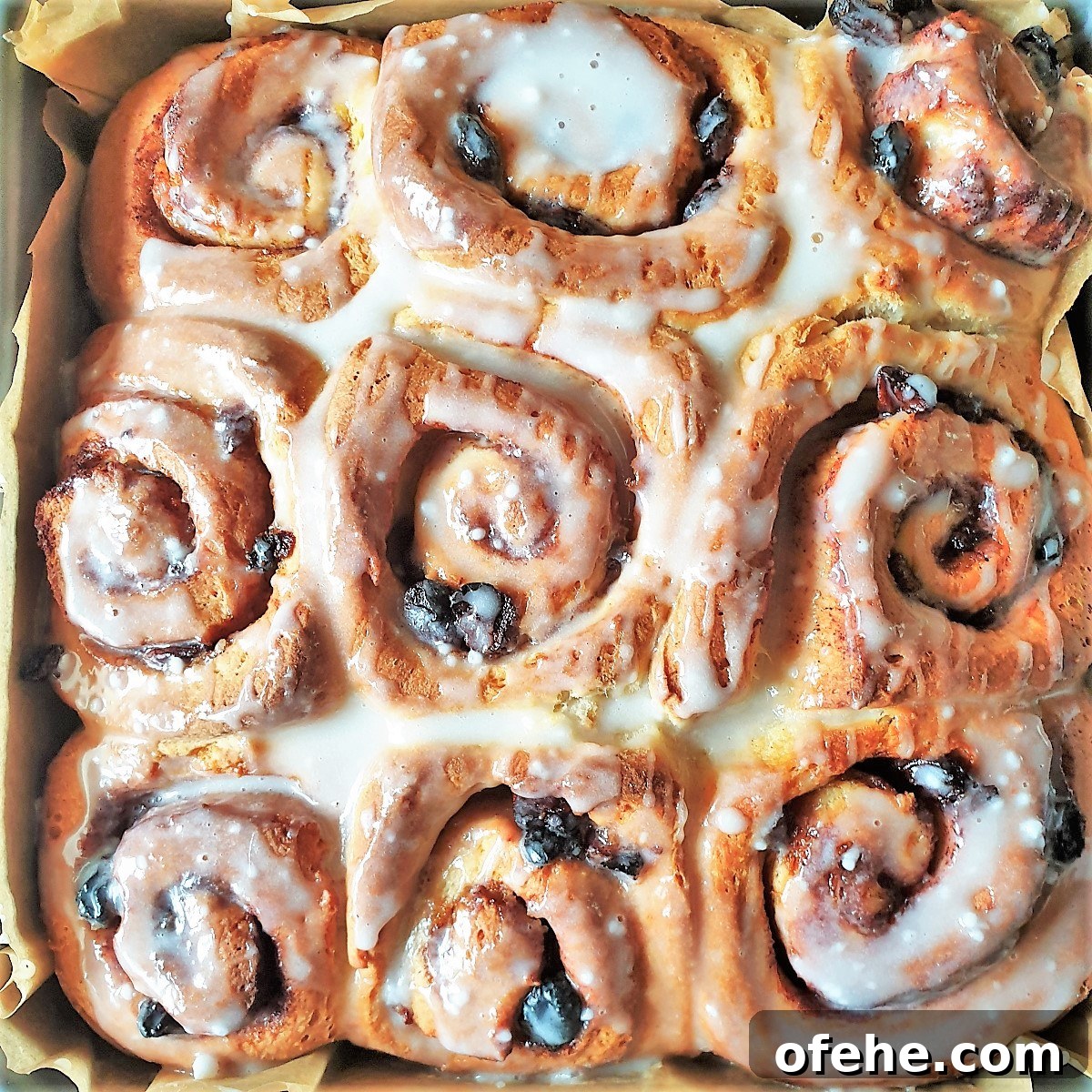 Homemade Chelsea Buns: Soft Cinnamon-Spiced Sticky Buns 19 A tray of baked chelsea buns covered with glaze.