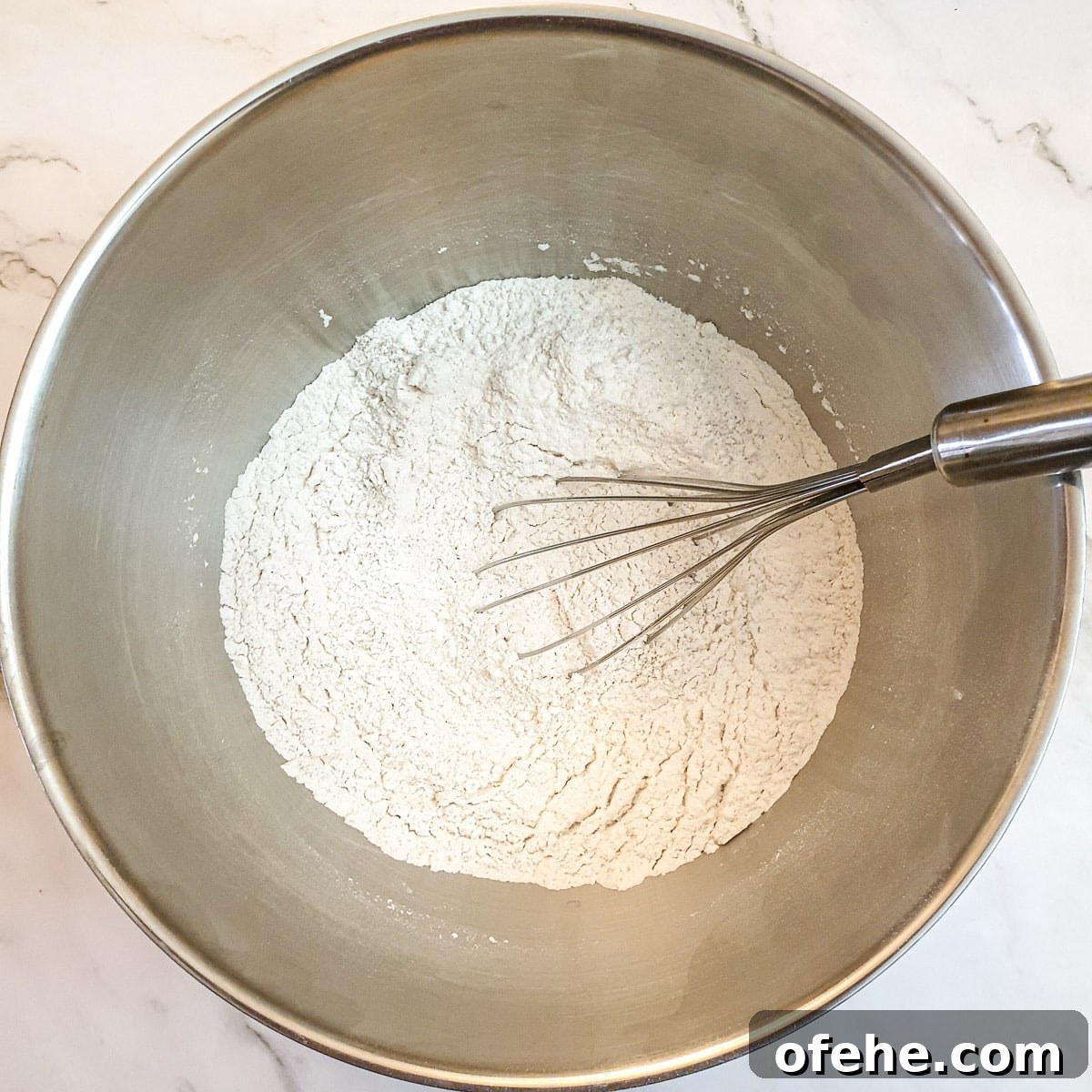 Homemade Chelsea Buns: Soft Cinnamon-Spiced Sticky Buns 7 Flour and dry ingredients being whisked to combine.