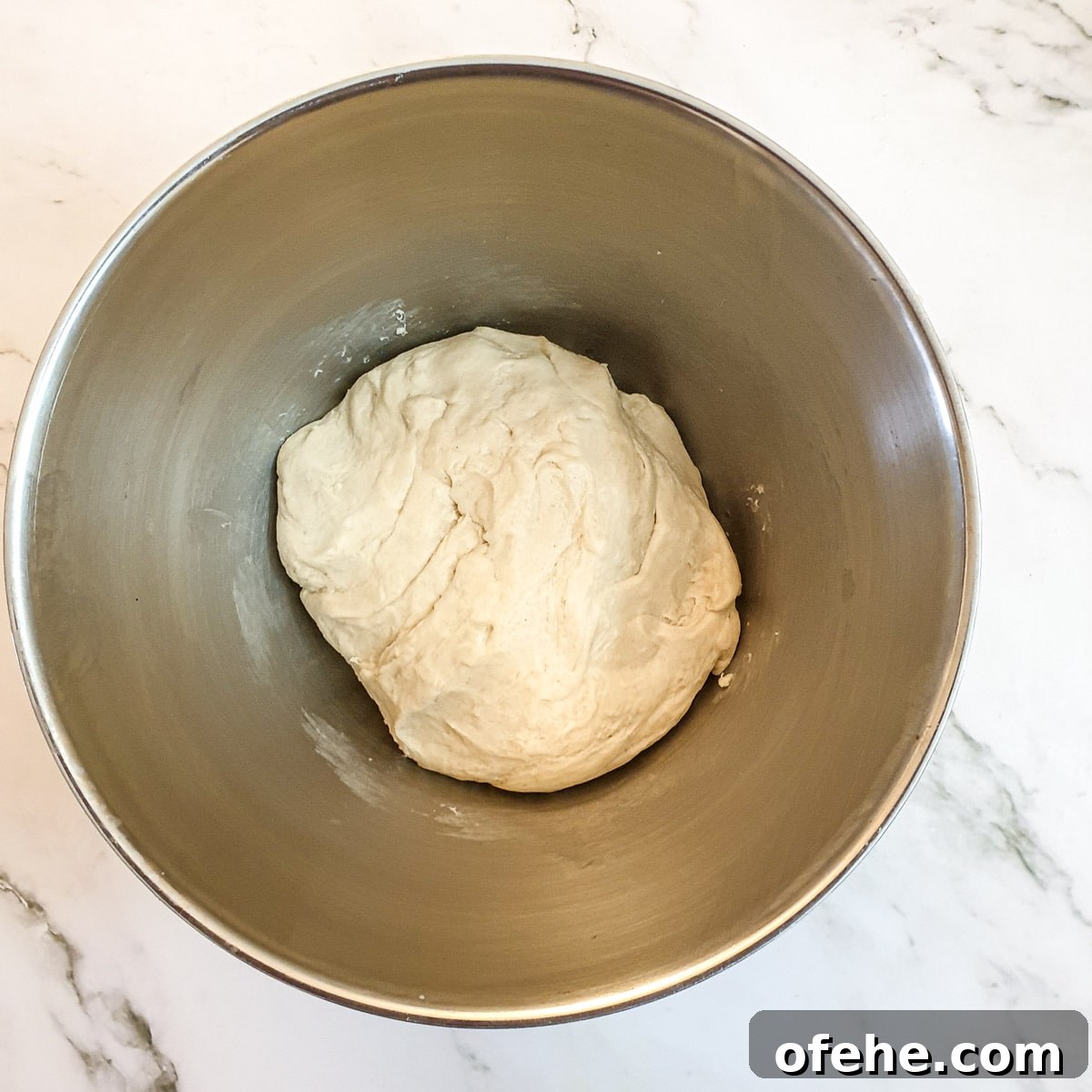 Homemade Chelsea Buns: Soft Cinnamon-Spiced Sticky Buns 9 A ball of mixed dough in a mixing bowl.