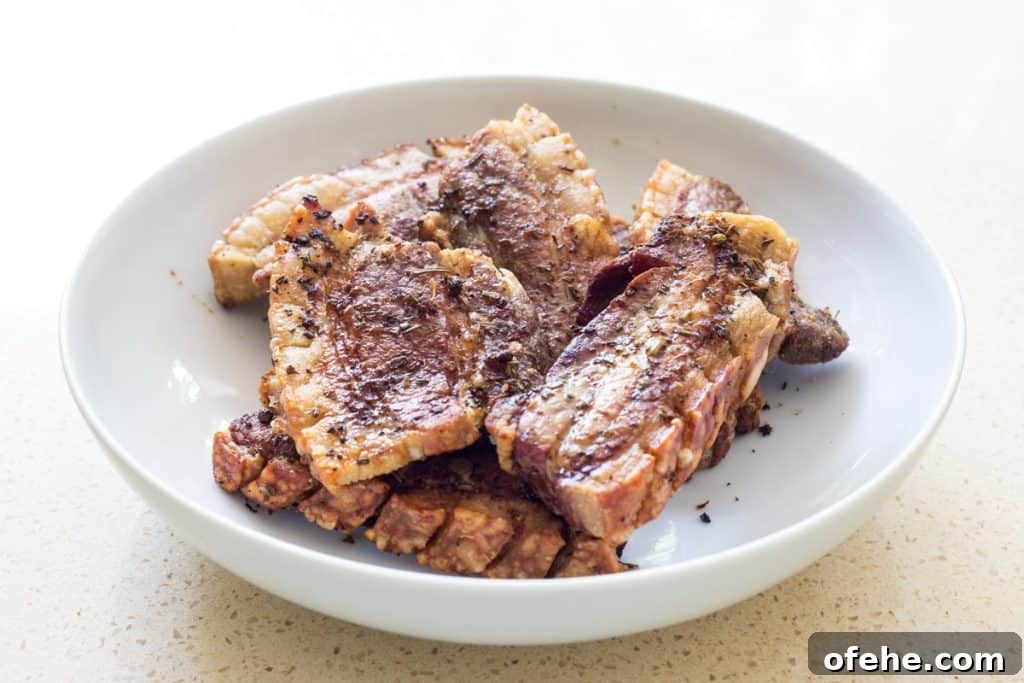 Freshly roasted pork belly strips resting in a bowl
