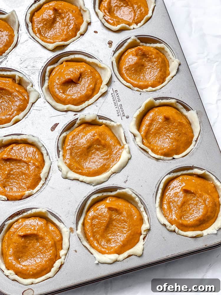 Mini Pumpkin Pie Recipe: Perfect Individual Fall Desserts 6 process shot showing pumpkin mixture added to muffin tin