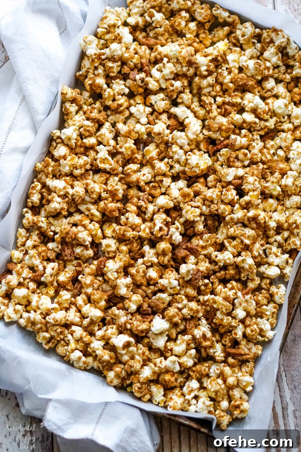Salted Caramel Pecan Popcorn Recipe — Sweet & Crunchy Snack 8 The caramel corn is spread out on a lined cookie sheet to let cool.
