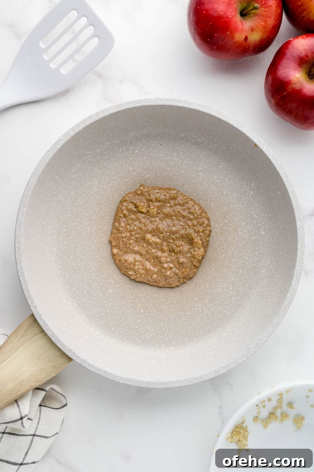 Apple Quinoa Pancakes That Crisp Up Perfectly 12 Uncooked pancake in skillet.