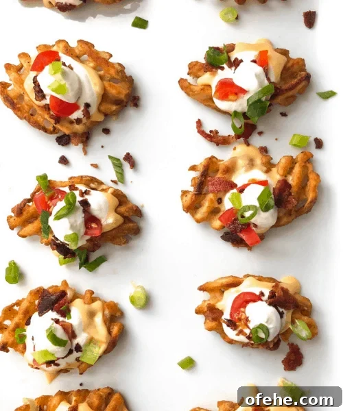 waffle fries on a dish topped with sour cream bacon and chives.