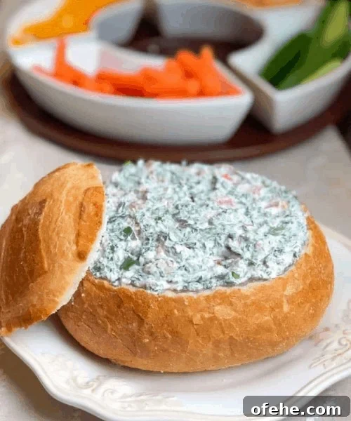 spinach dip inside of a hallowed out round baguette.