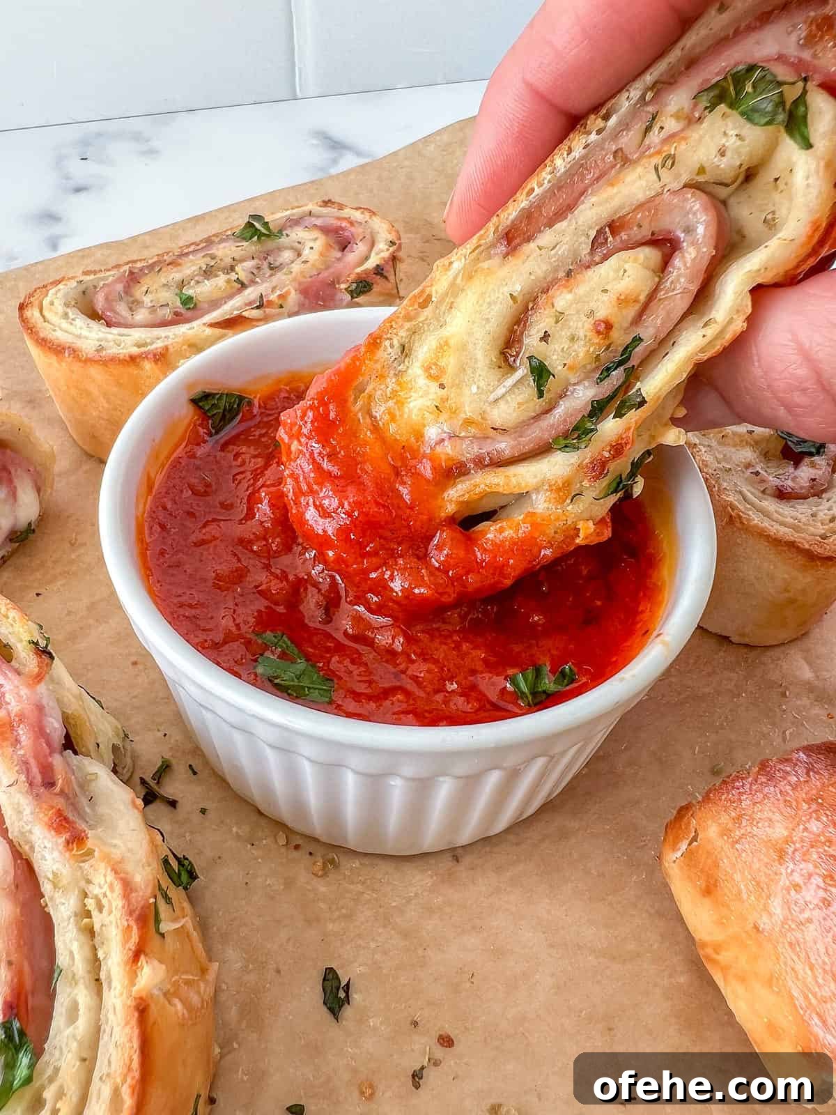 Stromboli stuffed with cheese and meats dipped into tomato sauce.