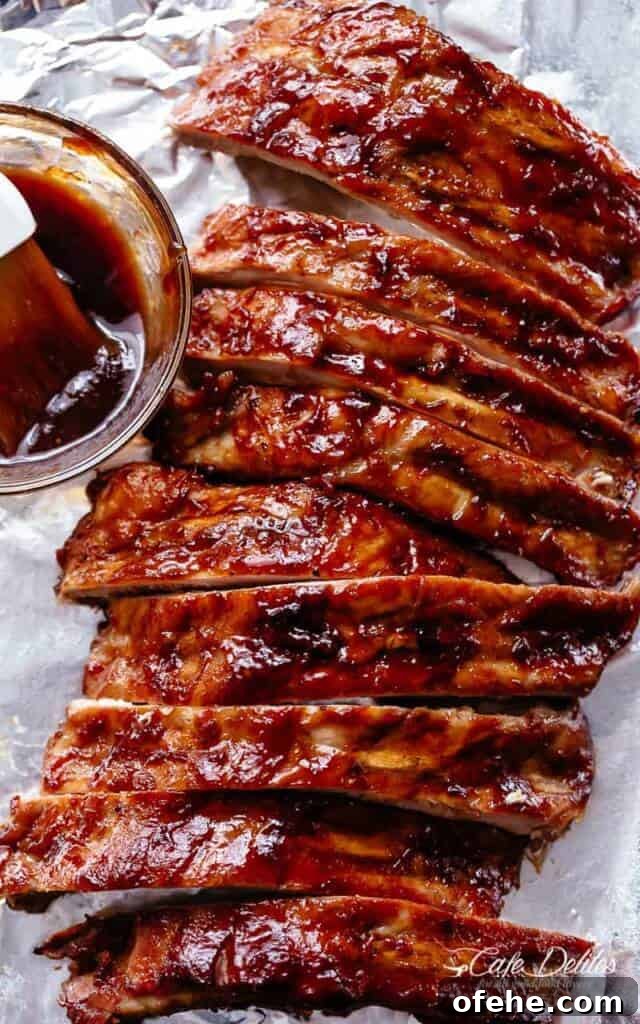 Slow cooker ribs slathered in a bbq sauce over tin foil.