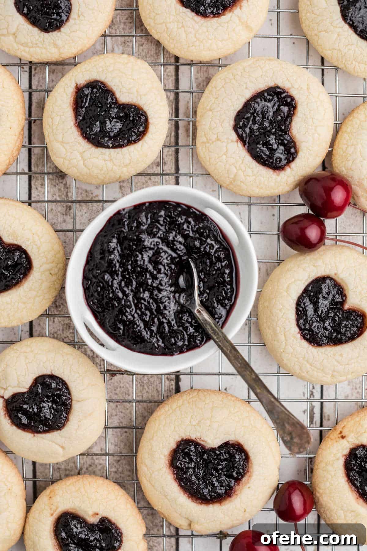 TikTok-Inspired Jam Heart Cookies Recipe 5 Jam heart cookies surrounding a small bowl filled with Cherry Jam.