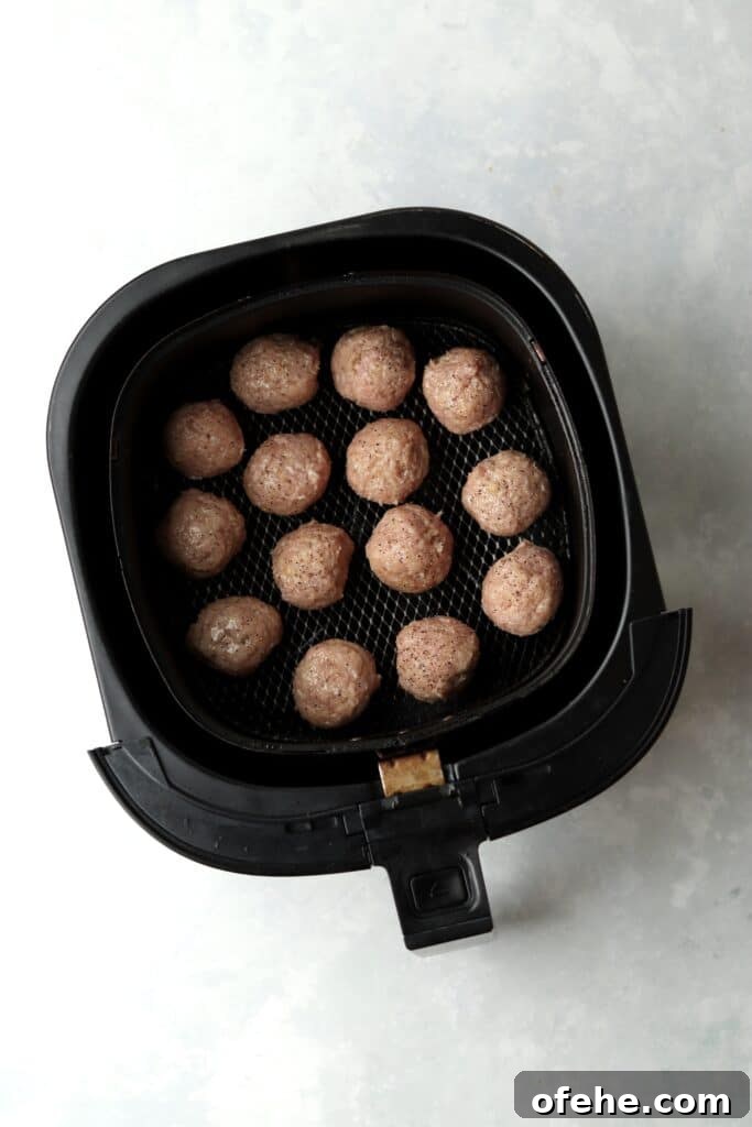 Crispy Air Fryer Turkey Meatballs Recipe for Quick Dinners 7 raw turkey meatballs in an air fryer basket