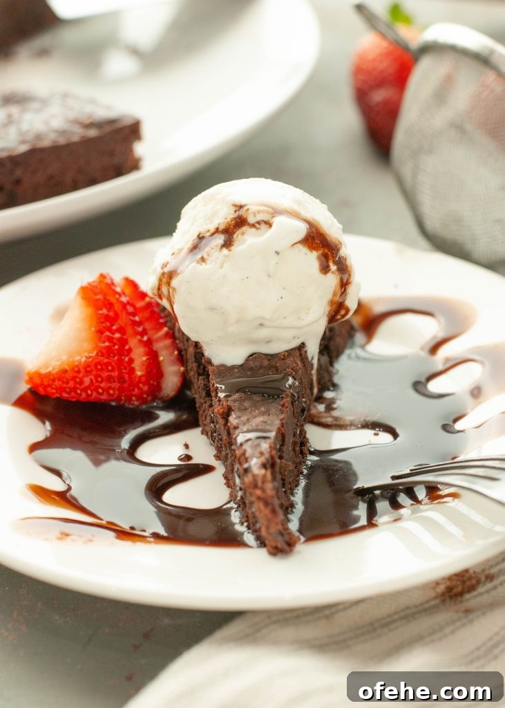 Flourless Chocolate Torte (Gluten-Free) Recipe + Video Tutorial 2 flourless-chocolate-torte-with-ice-cream-and-chocolate-sauce-on-top-with-a-strawberry-next-to-it-straight-on