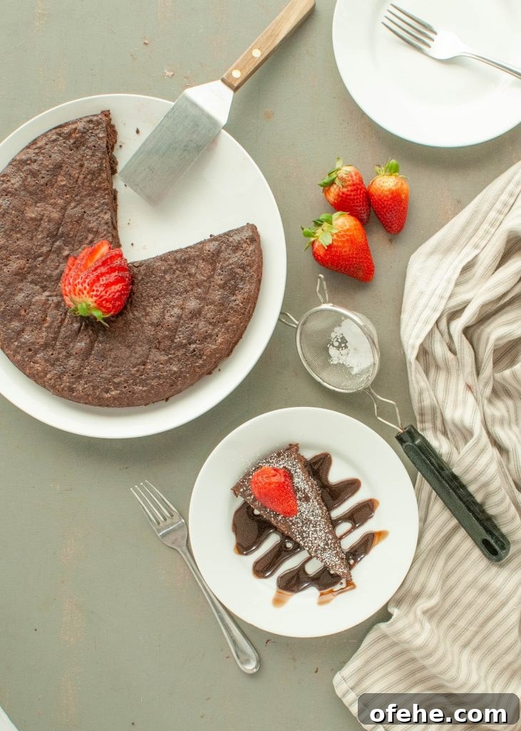 Flourless Chocolate Torte (Gluten-Free) Recipe + Video Tutorial 3 flourless-chocolate-torte-with-one-slice-on-a-plate-rest-of-cake-in-the-pan-shot-from-above-with-strawberries