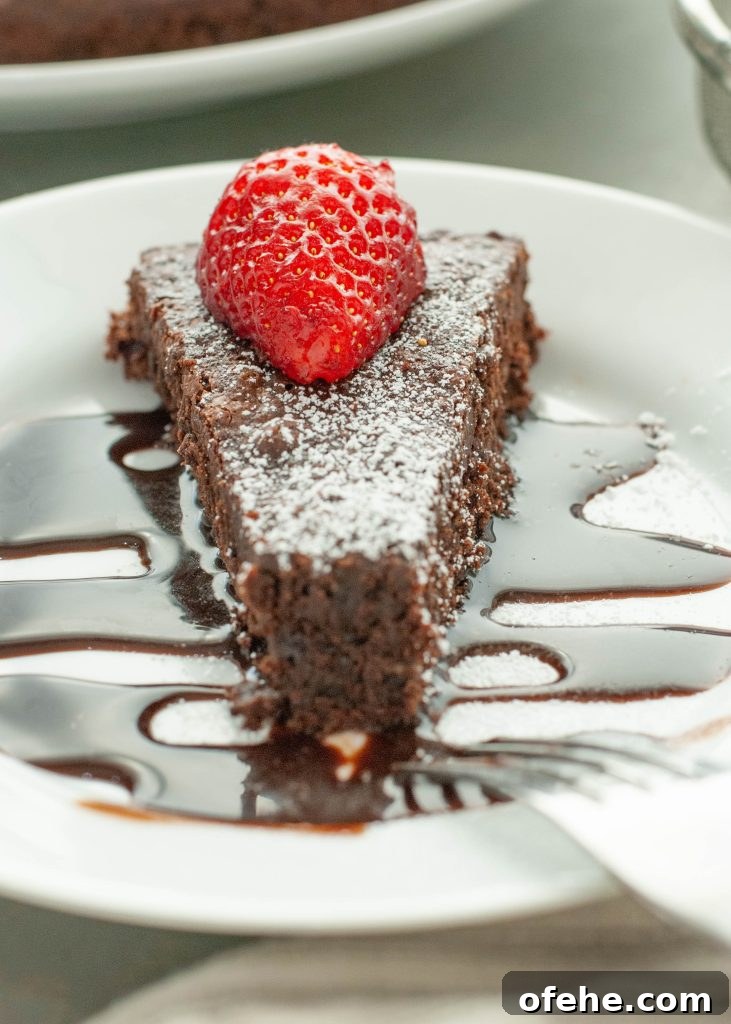 Flourless Chocolate Torte (Gluten-Free) Recipe + Video Tutorial 4 flourless -chocolate-cake-slice-with-chocolate-sauce-and-strawberry-on-top-with-bite-taken