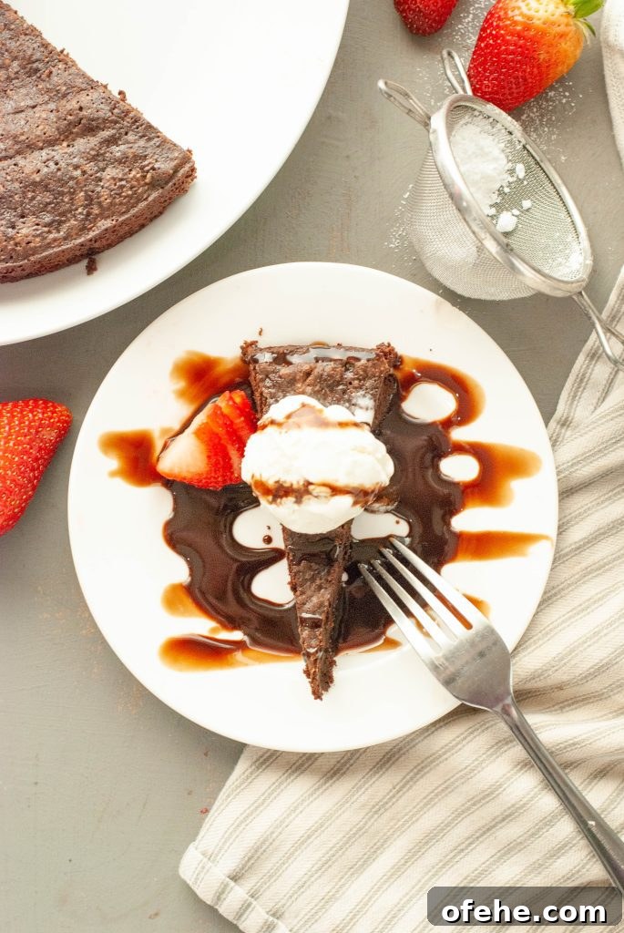 Flourless Chocolate Torte (Gluten-Free) Recipe + Video Tutorial 5 flourless-chocolate-torte-slice-shot-from-above-with-vanilla-ice-cream-and-chocolate-sauce-on-top