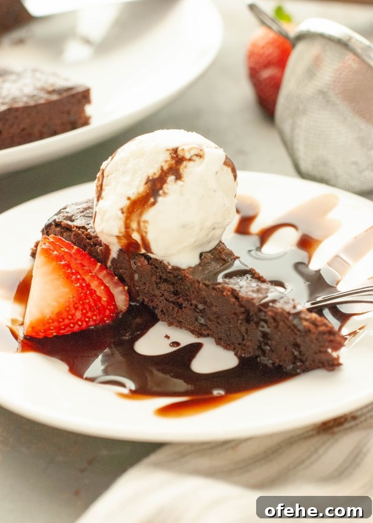 Flourless Chocolate Torte (Gluten-Free) Recipe + Video Tutorial 7 flourless-chocolate-torte-slice-side-angle-with-chocolate-sauce-and-vanilla-ice-cream-on-top