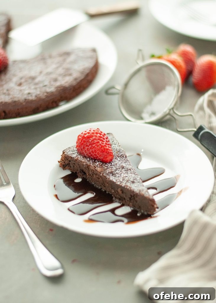 Flourless Chocolate Torte (Gluten-Free) Recipe + Video Tutorial 8 flourless-chocolate-tort-eslice-sitting-on-top-of-chocolate-sauce-with-strawberry-on-top
