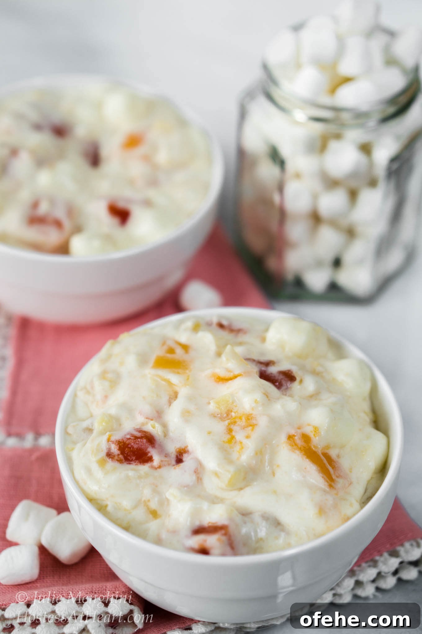 Creamy Tropical Fruit Cocktail Salad Recipe That Impresses 2 2 bowls of Tropical Fruit Cocktail Salad with a jar of marshmallows