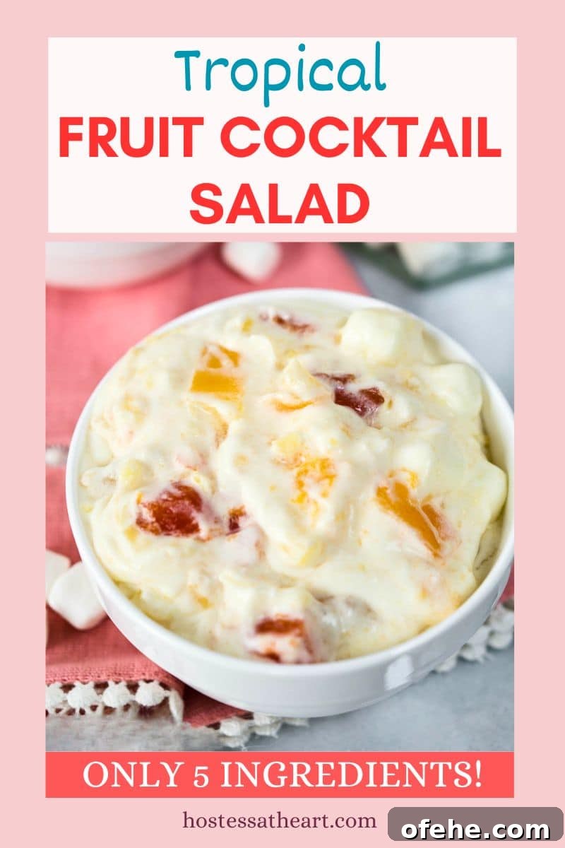 Creamy Tropical Fruit Cocktail Salad Recipe That Impresses 5 Image for Pinterest of a bowl of fruit cocktail salad made with whipped topping and pudding - Hostess At Heart
