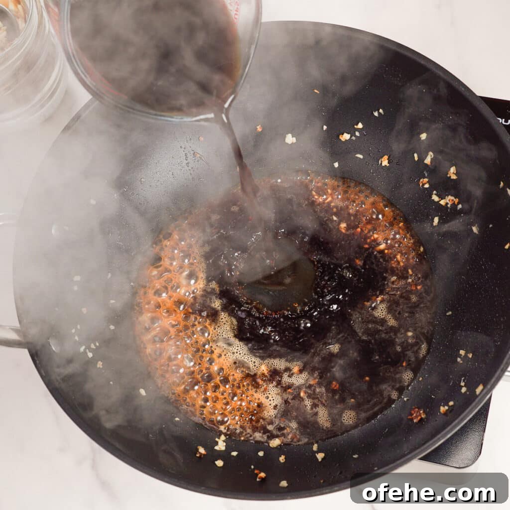 Garlic Chicken with Broccoli Stir-Fry Recipe 7 Sauce being poured into wok