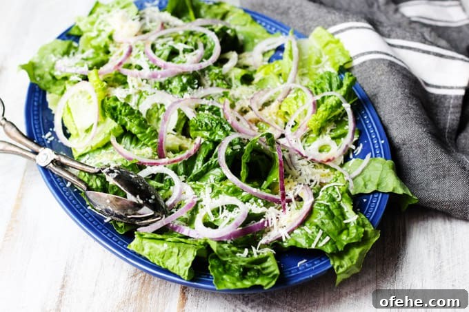 Crisp Spring Green Salad with Lemon-Herb Vinaigrette 7 Simple green salad on serving blue plate with kitchen towel on a side