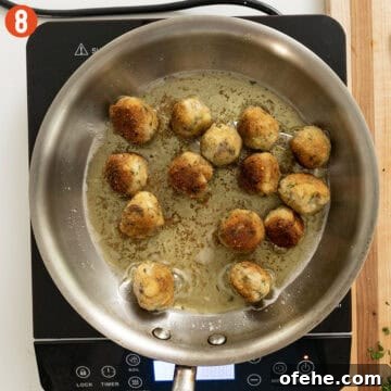 Italian Eggplant Meatballs in Tomato Sauce 11 Golden-brown eggplant meatballs in a frying pan.