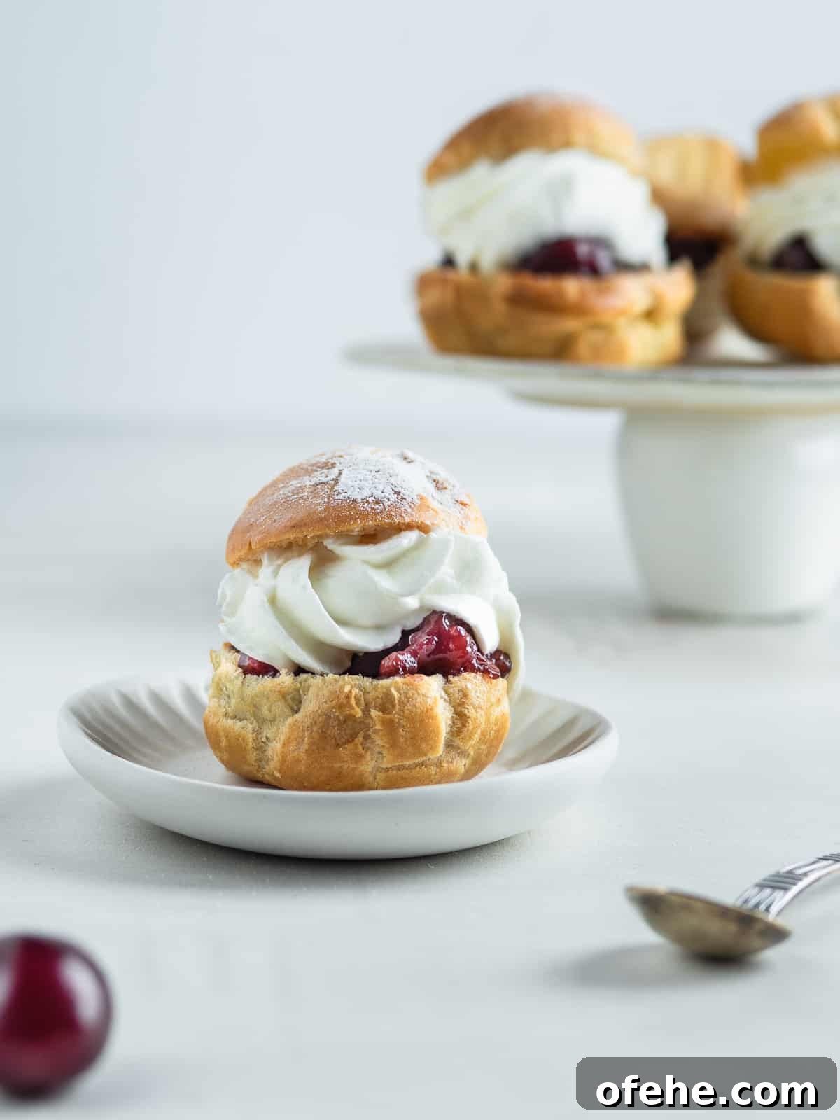 Windbeutel: Classic German Cream Puffs Recipe 5 Windbeutel on a dessert plate and a cake stand