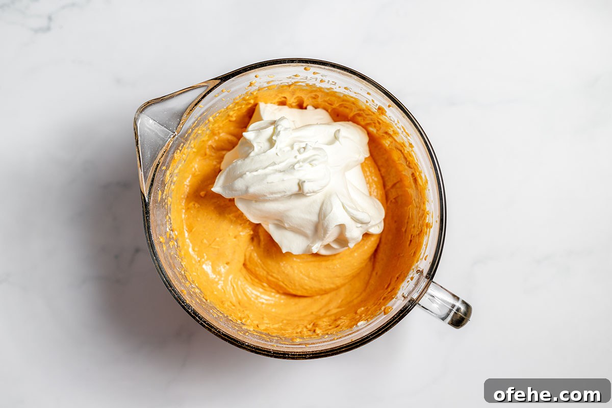 Whipped cream folded into pumpkin cheesecake batter.