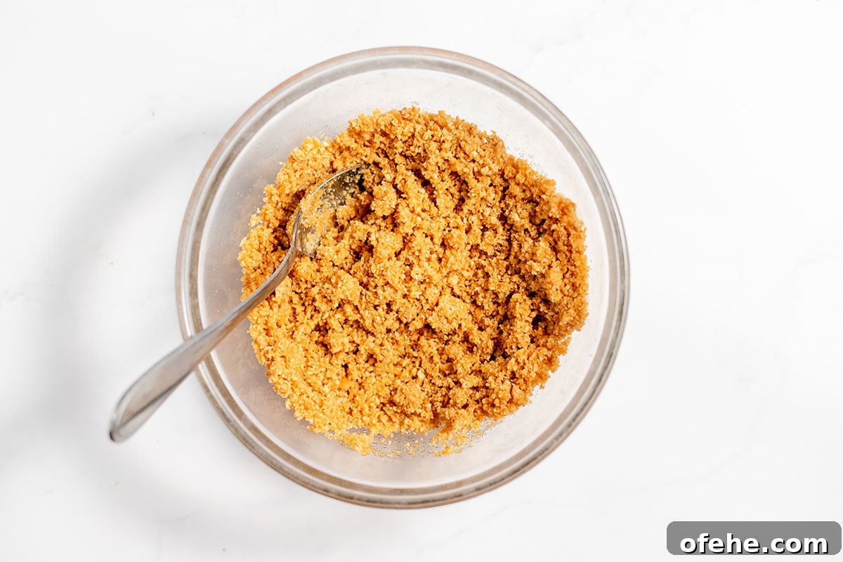 Graham cracker crust ingredients are mixed together in a bowl.