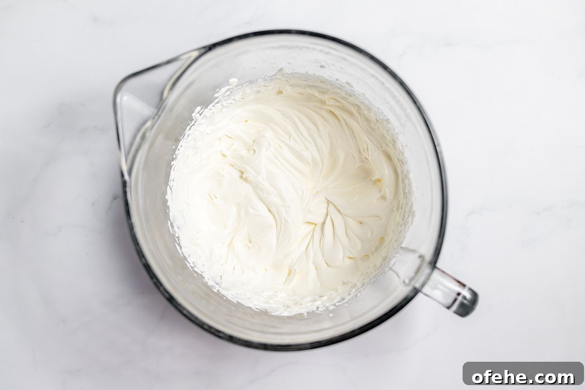 Whipped heavy cream in a mixing bowl.