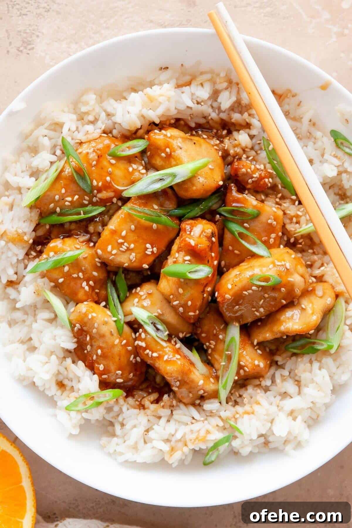 Crispy Sticky Air Fryer Teriyaki Chicken 10 Healthy air fryer teriyaki chicken served in a bowl with white rice and sesame seeds.
