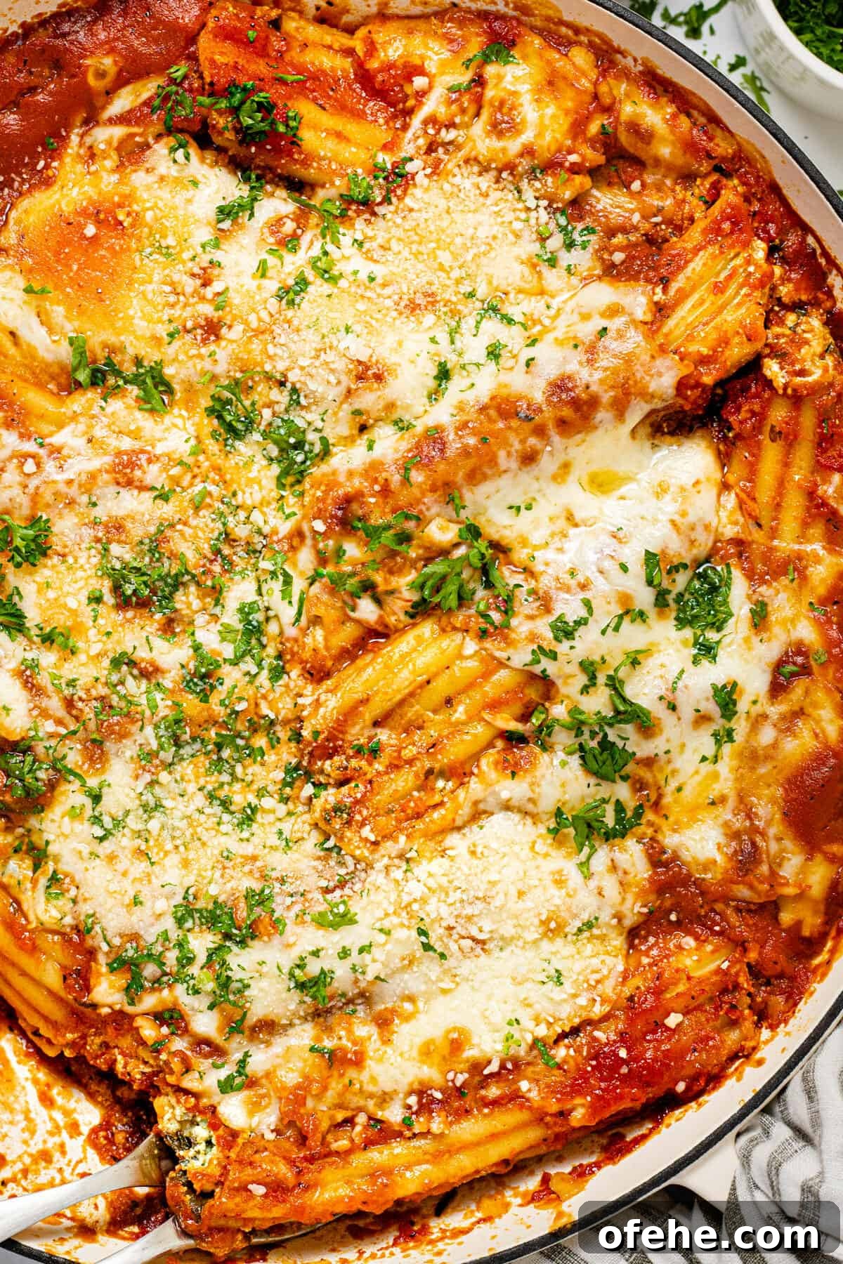 Creamy Spinach and Cheese Manicotti (Vegetarian Recipe) 8 Large white baking dish filled with fresh baked homemade cheesy baked manicotti garnished with fresh parsley