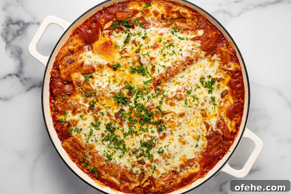 Creamy Spinach and Cheese Manicotti (Vegetarian Recipe) 6 Large white baking dish filled with fresh baked homemade cheesy baked manicotti garnished with fresh parsley