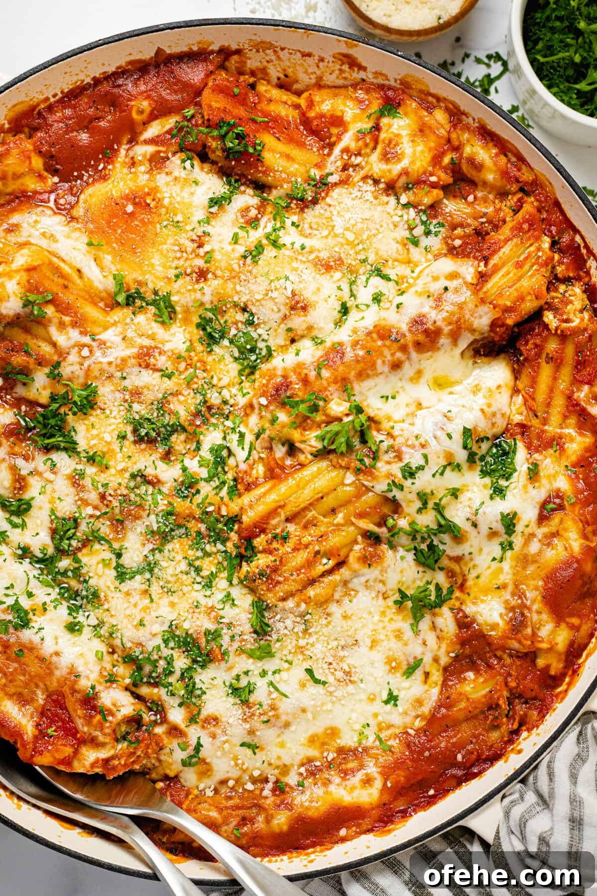 Creamy Spinach and Cheese Manicotti (Vegetarian Recipe) 7 Large white baking dish filled with fresh baked homemade cheesy baked manicotti garnished with fresh parsley