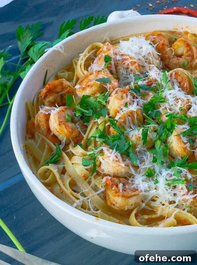 white bowl of roastedred pepper pasta on gray background with parsley