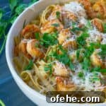 white bowl of roasted red pepper pasta on gray background with parsley