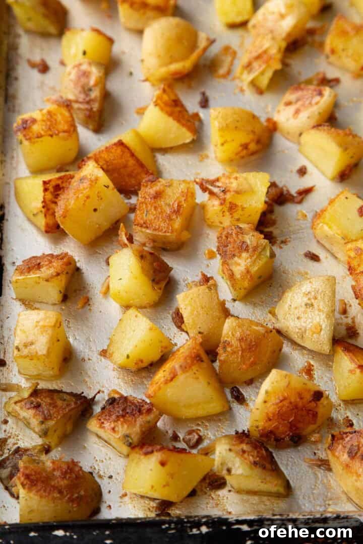 French Onion Soup Potatoes Recipe with Caramelized Onions 8 partially cooked cubed potatoes on a baking sheet with some crispy brown parts.