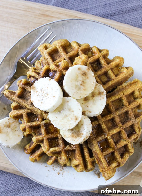 Pumpkin Banana Waffle Recipe with Cinnamon Maple Syrup 2 waffles topped with sliced bananas and sprinkled with cinnamon