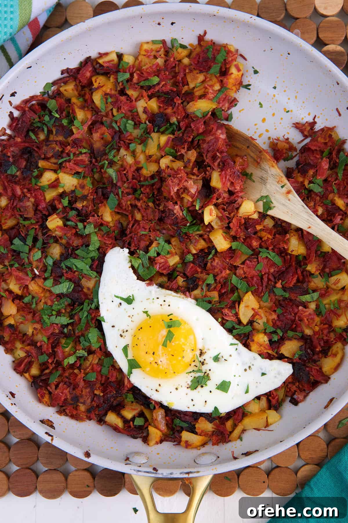 A fried egg is placed in a skillet with corned beef hash.