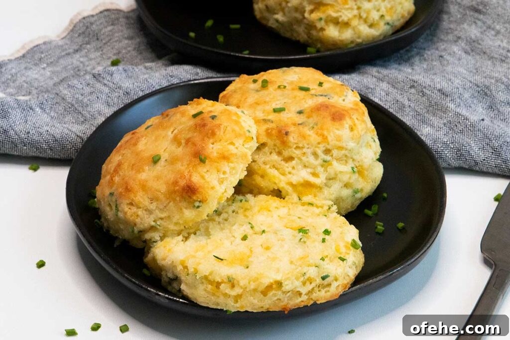 Cheddar chive biscuits on black plate.