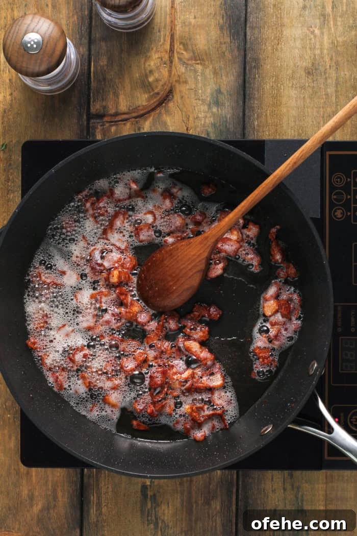 Bacon being cooked in a black skillet.