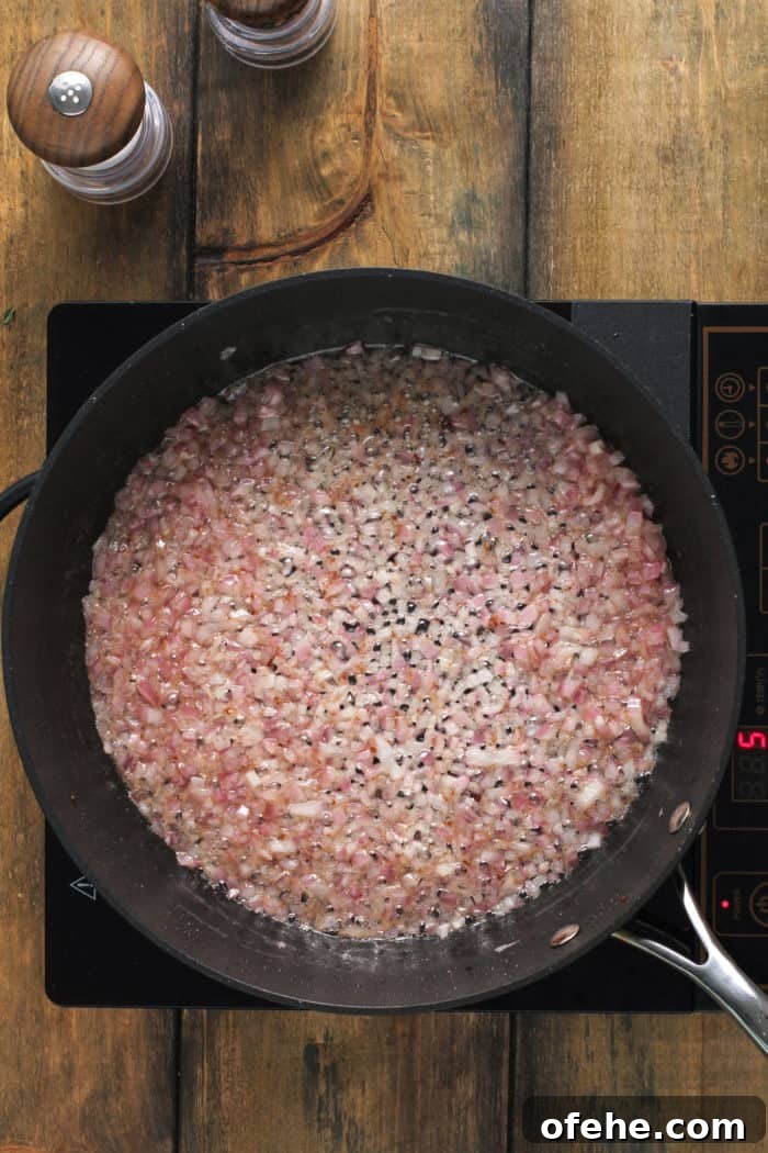 Hot bacon dressing for german potato salad being cooked in a black skillet.