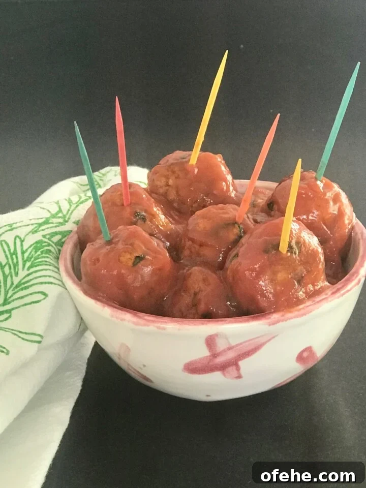 Vegan Sweet and Sour Meatballs in a small dish with colorful toothpics.