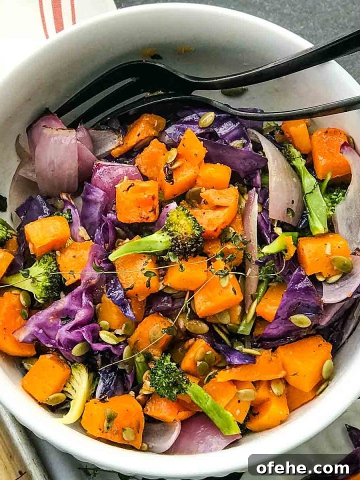 Bowl of roasted butternut with purple cabbage, onions, broccoli and fresh herbs.