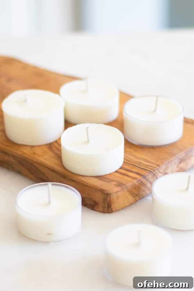 DIY Citronella Candles to Keep Mosquitoes Away 4 homemade citronella candles on wooded cutting board.