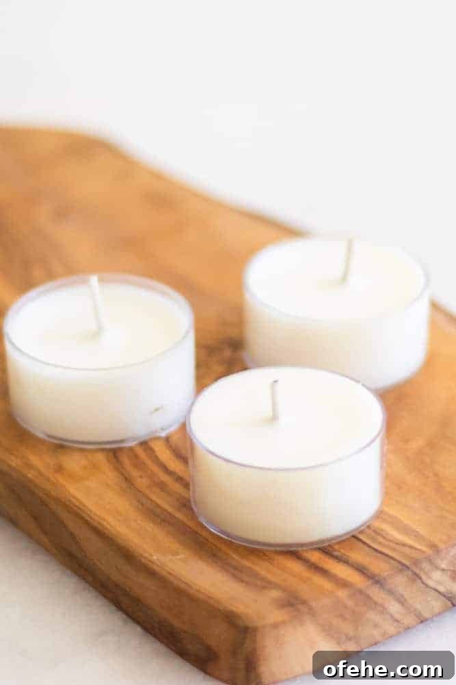 DIY Citronella Candles to Keep Mosquitoes Away 8 three white tea light candles on wooden cutting board.