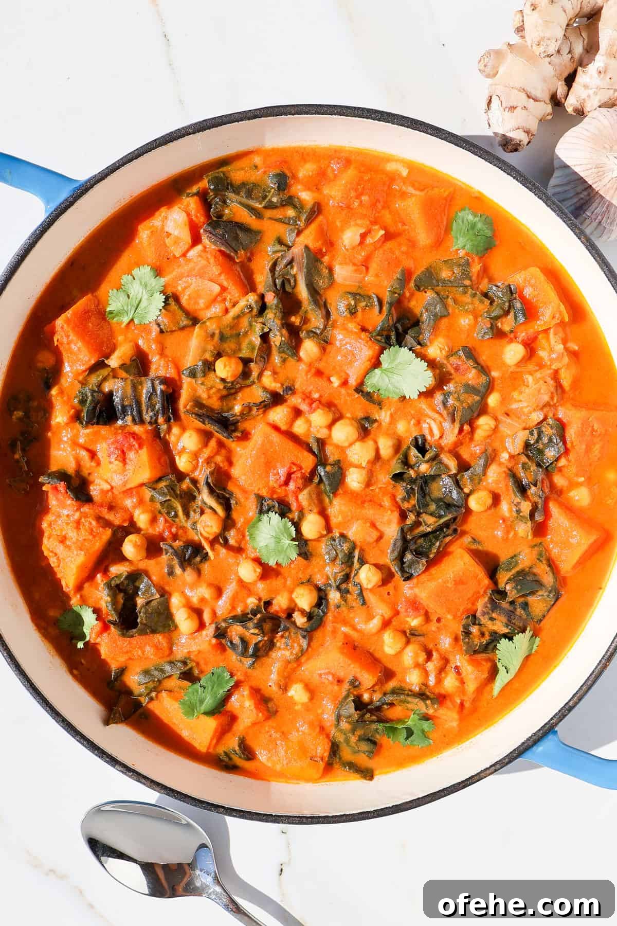 Butternut squash curry in a pot topped with coriander.