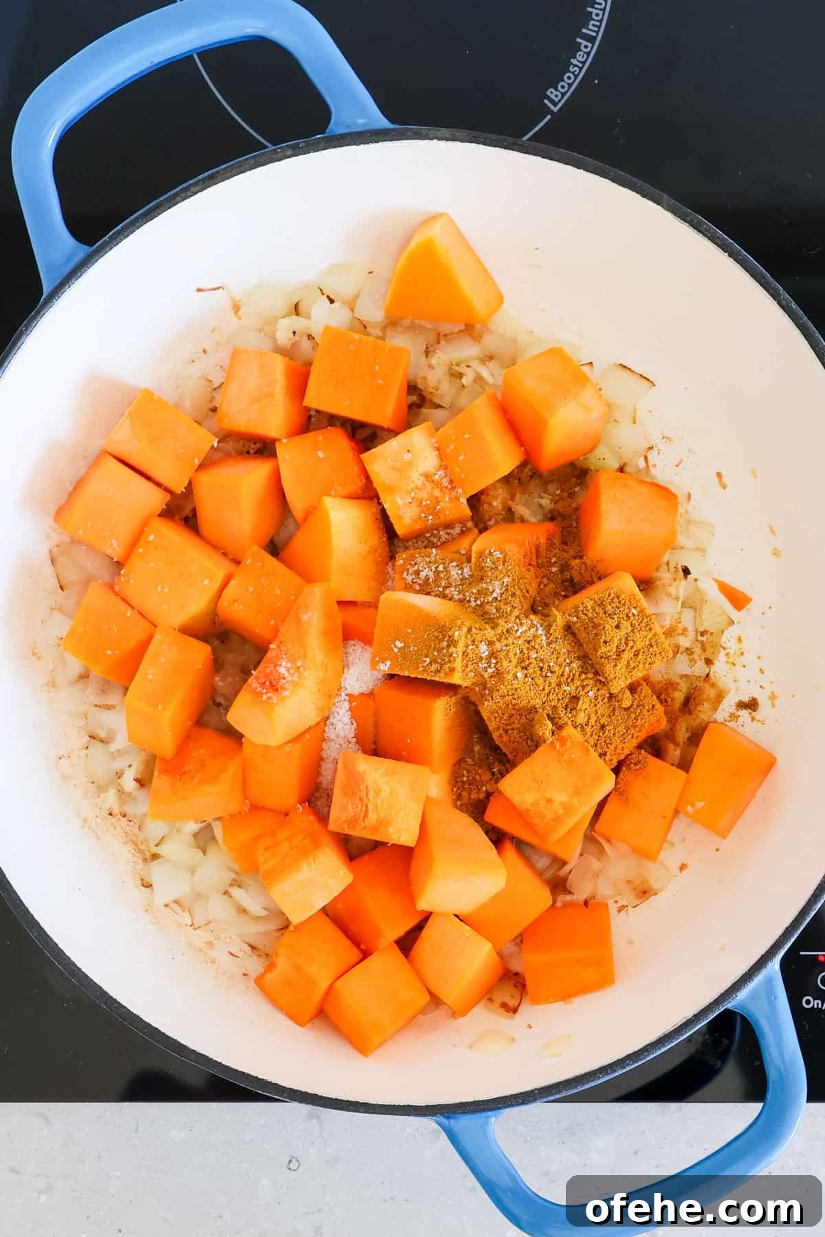 Butternut squash, curry powder and salt added to the pot.